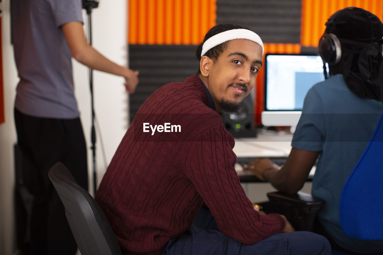 Side view of man sitting in recording studio