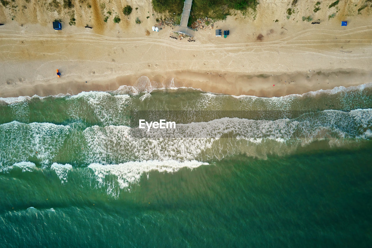 Sand beach with sea waves, top view