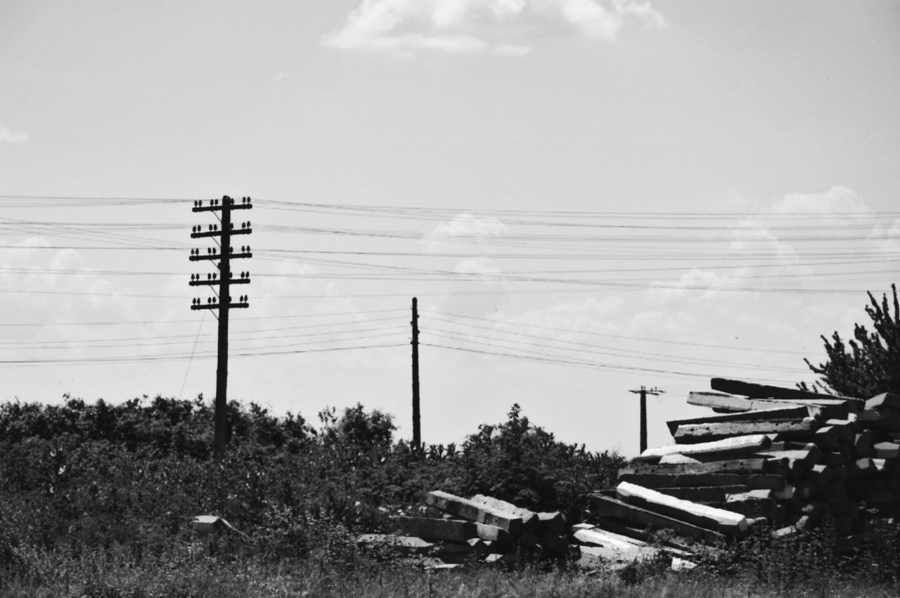 ELECTRICITY PYLON AND FLAG AGAINST SKY