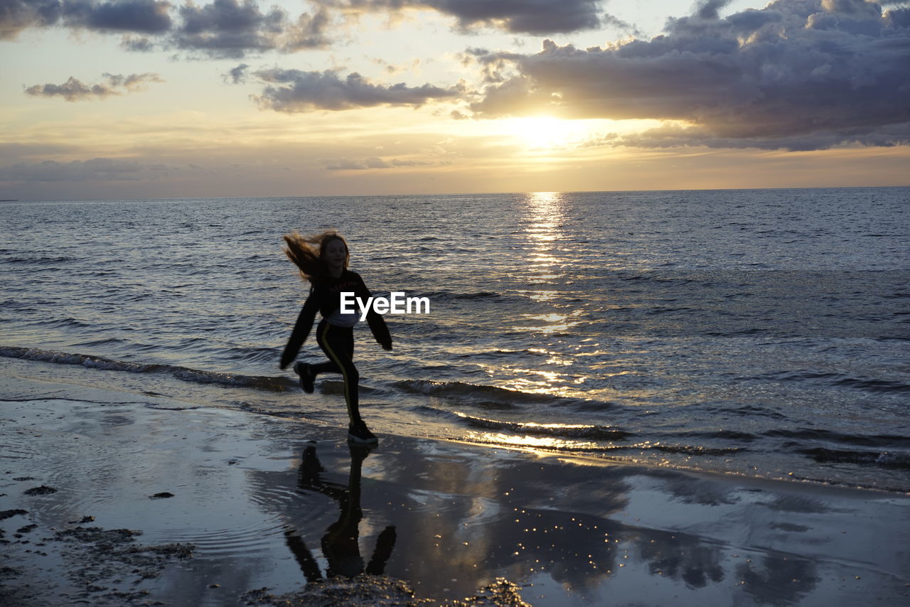 Full length of man on beach during sunset