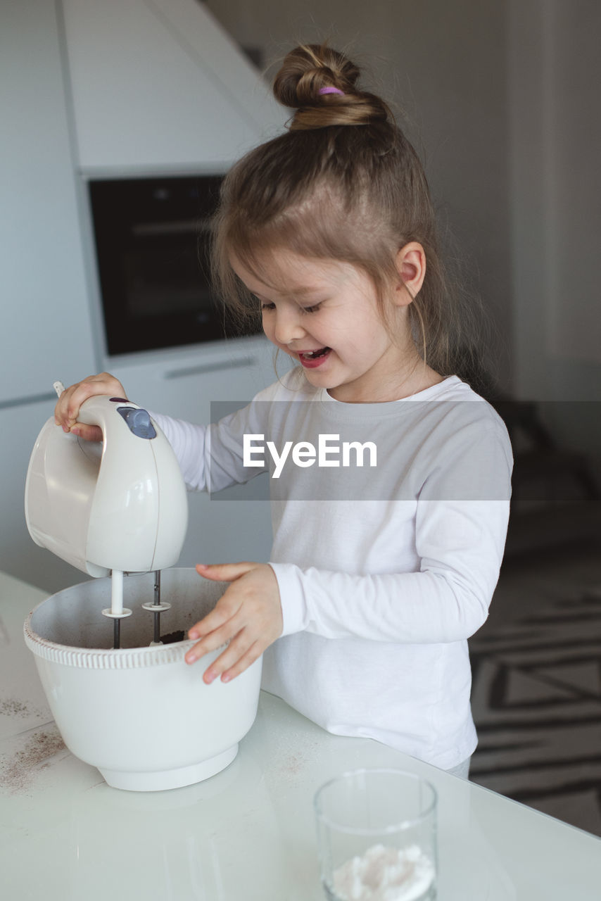 Cute girl making cake batter