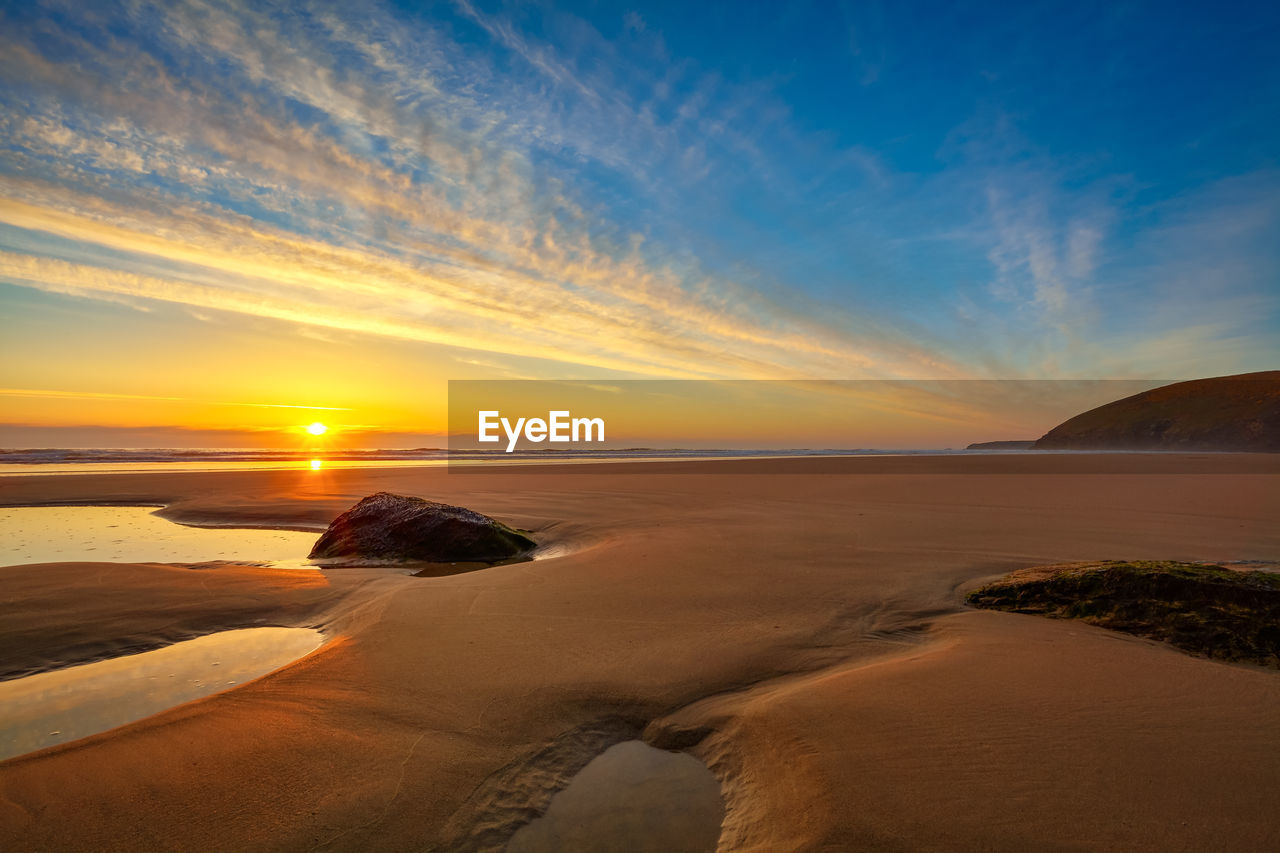 Scenic view of beach against sky during sunset