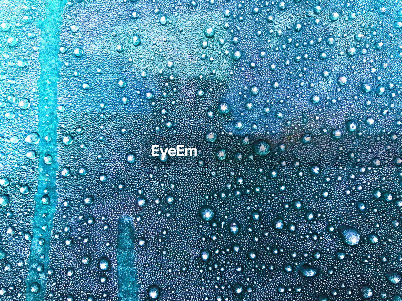 CLOSE-UP OF RAINDROPS ON GLASS WINDOW