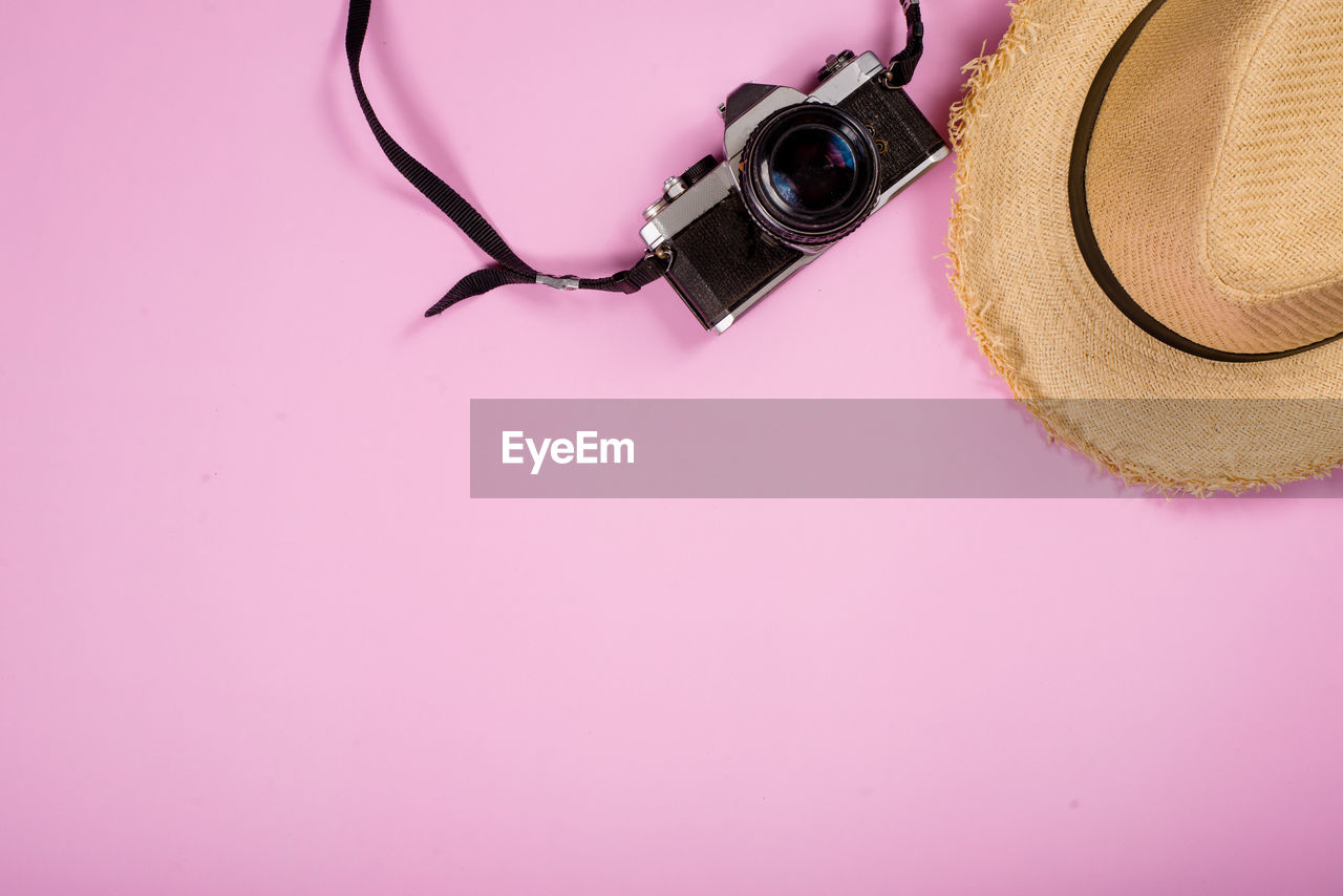 HIGH ANGLE VIEW OF DIGITAL CAMERA ON PINK PAPER