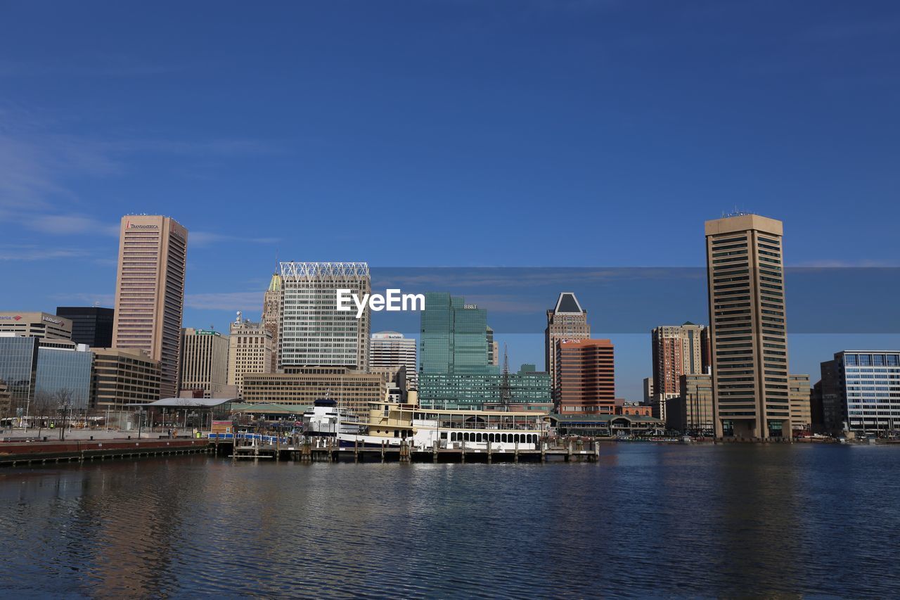 RIVER BY BUILDINGS AGAINST BLUE SKY