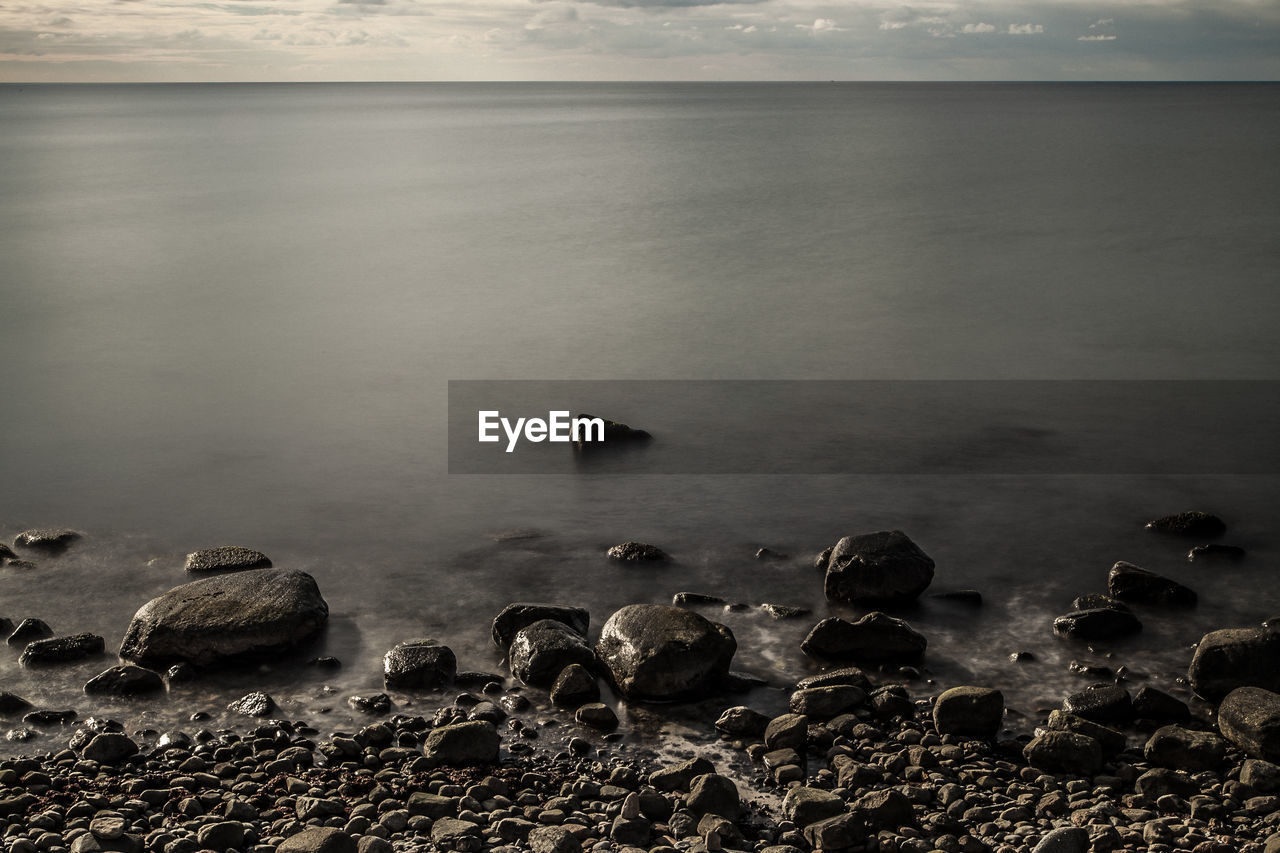 HIGH ANGLE VIEW OF ROCKS ON SEA SHORE