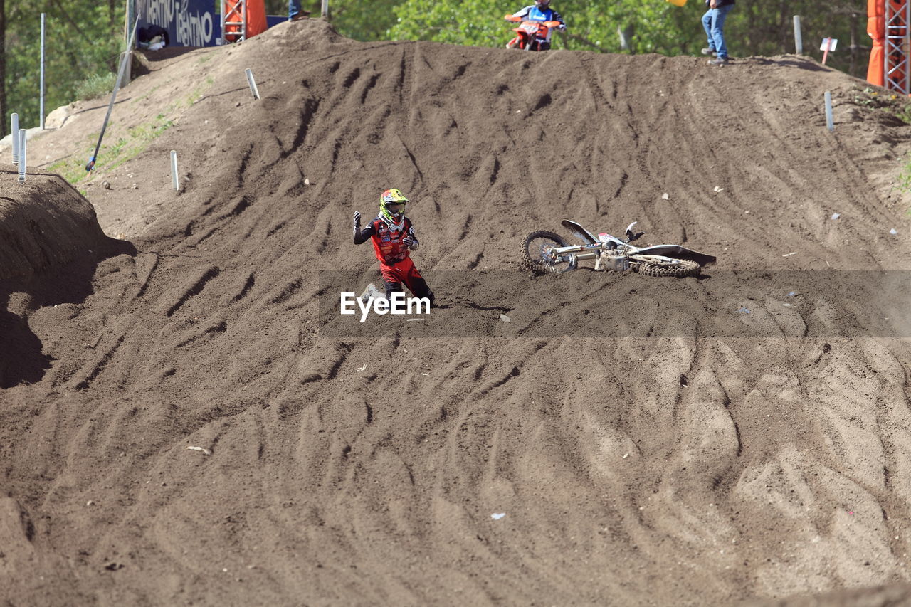 High angle view of sports person with motorbike on dirt