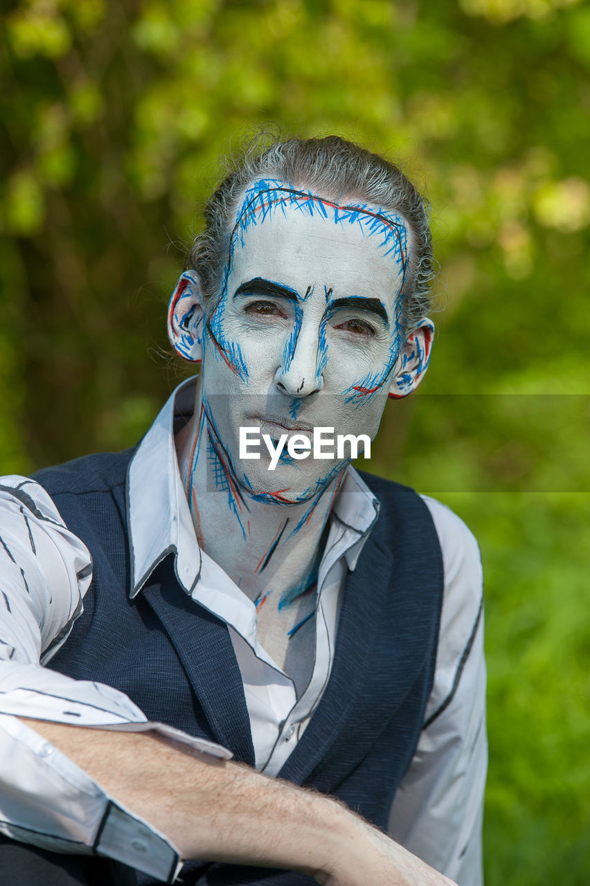 Portrait of man with face paint in park