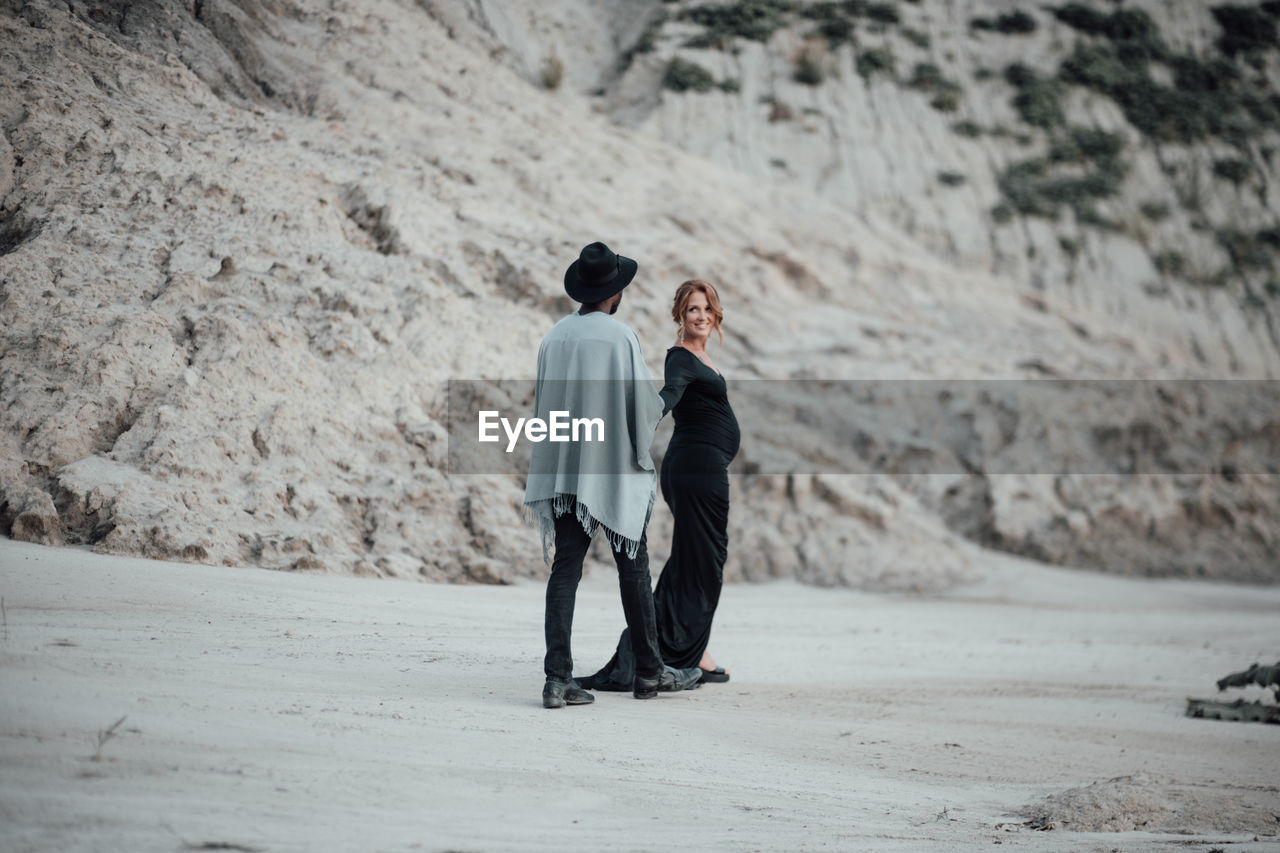 Rear view of couple standing on land