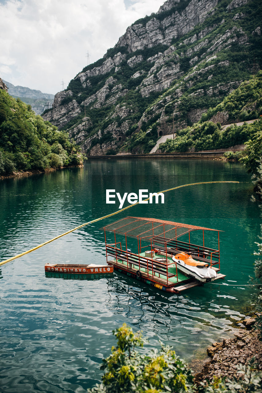 SCENIC VIEW OF RIVER BY MOUNTAINS AGAINST SKY