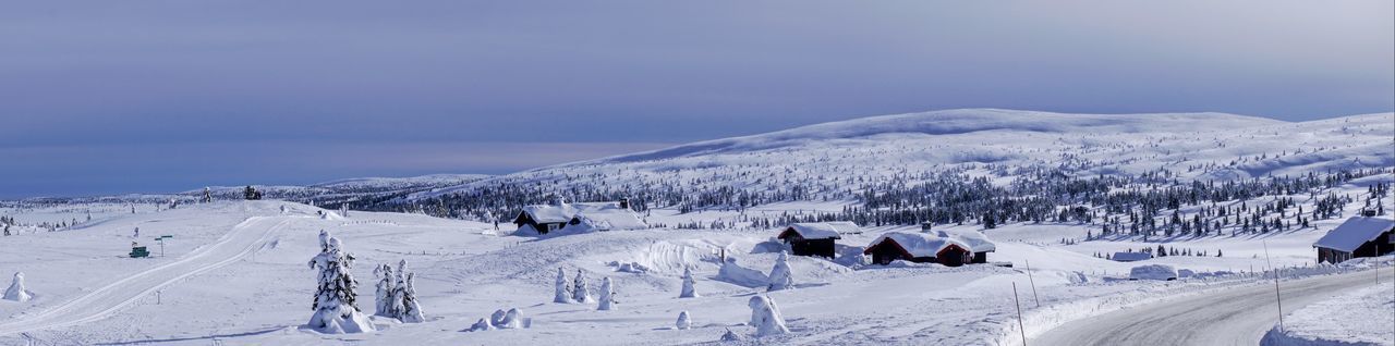 Panoramic view of snow covered landscape against sky