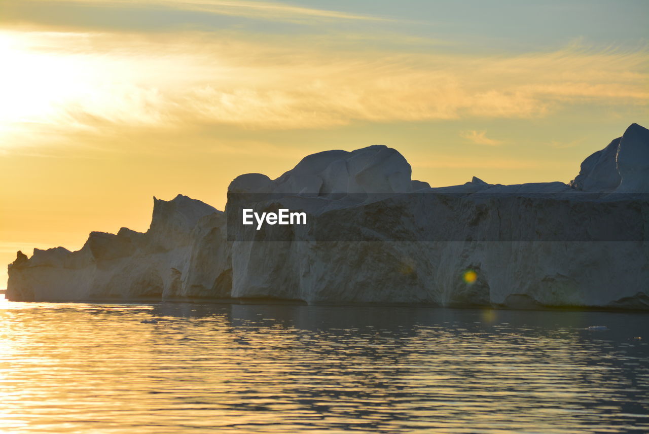 Scenic view of sea against clear sky with beautiful icebergs in the midnight sun ilulissat greenland