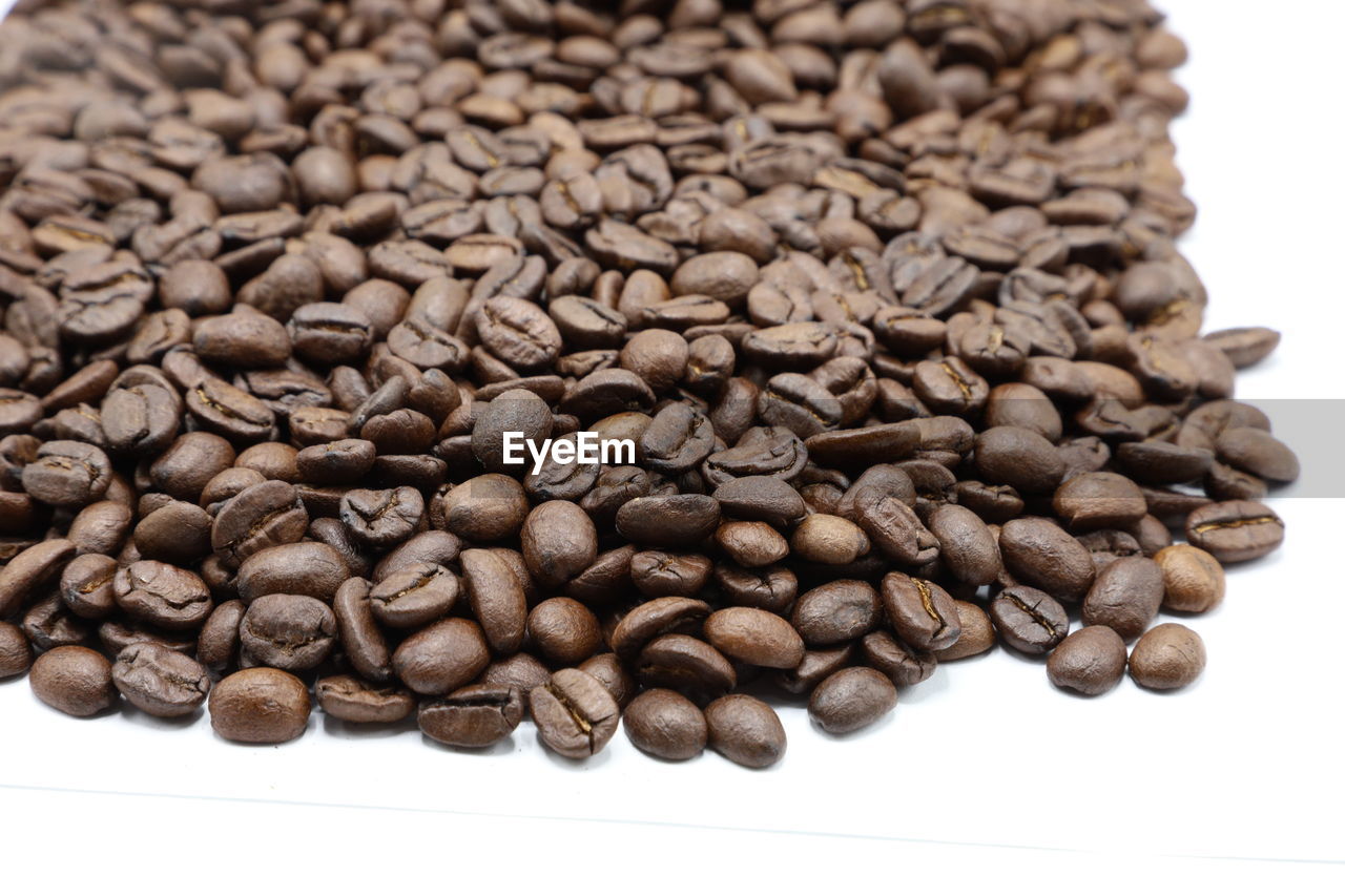 CLOSE-UP OF COFFEE BEANS ON WHITE BACKGROUND