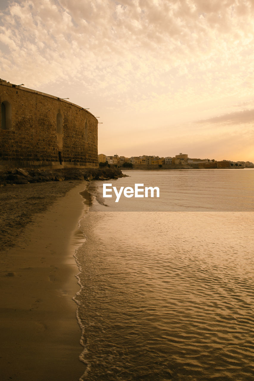 Dramatic sunset over the sea in cloudy sky, beautiful nature scene, horizon over water.