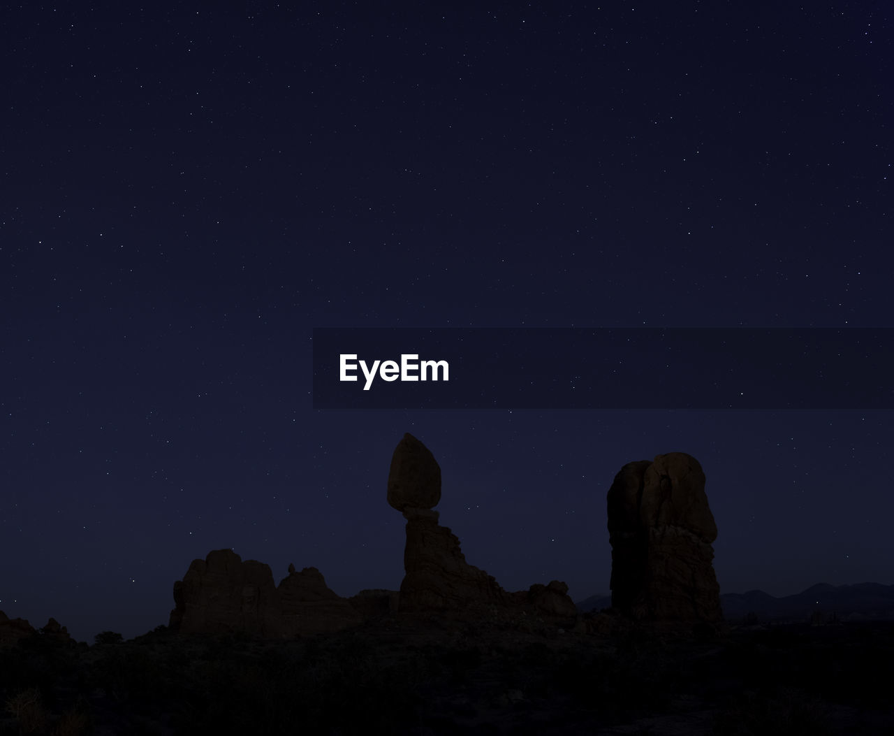 Low angle view of rock formation against sky at night