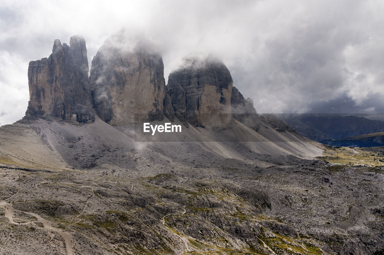 Scenic view of rock formations against cloudy sky