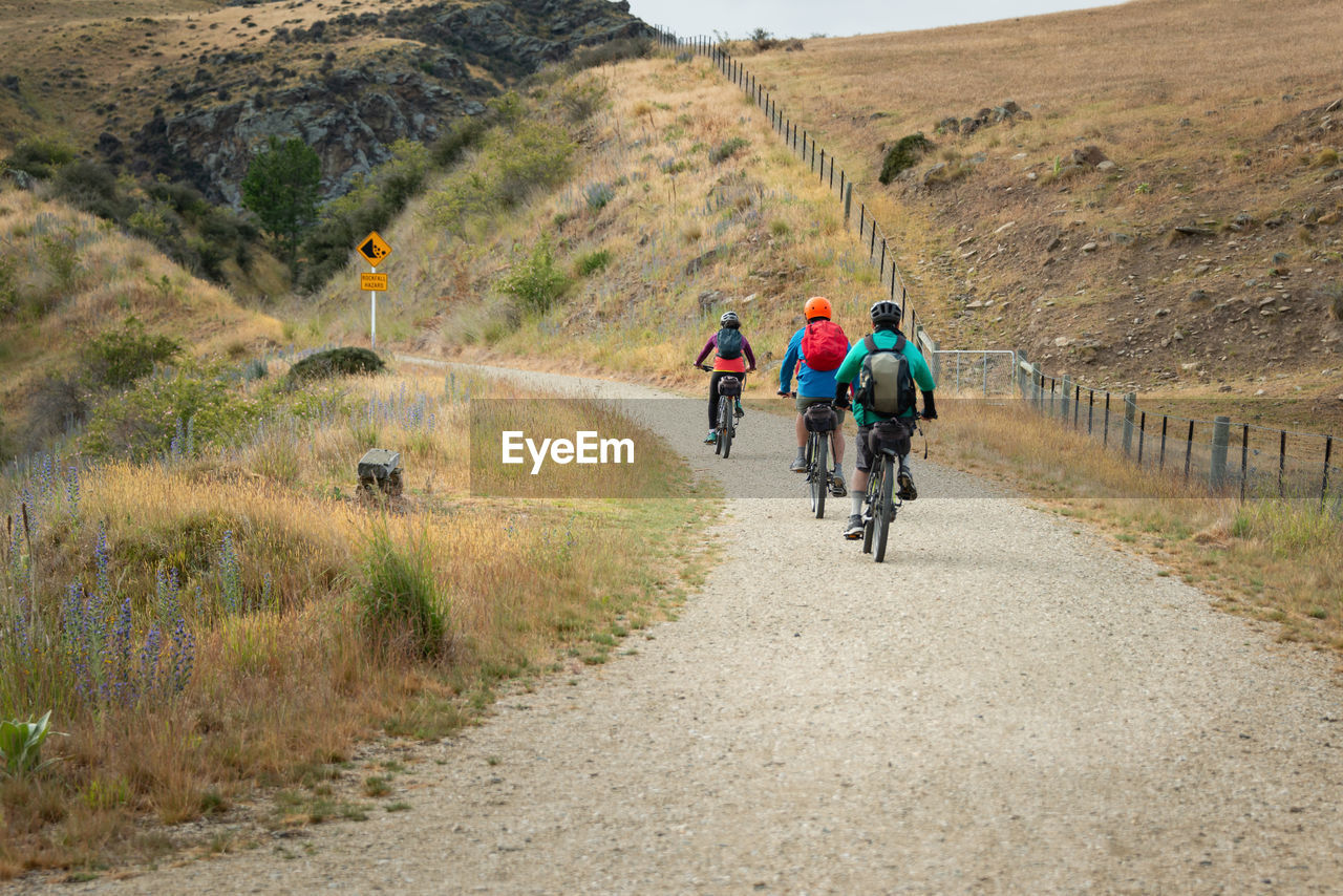 PEOPLE RIDING BICYCLE ON ROAD