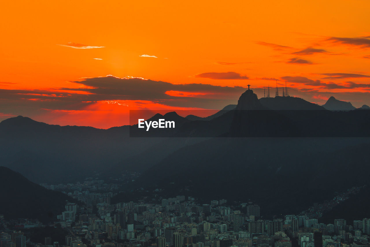 Scenic view of silhouette mountains against orange sky