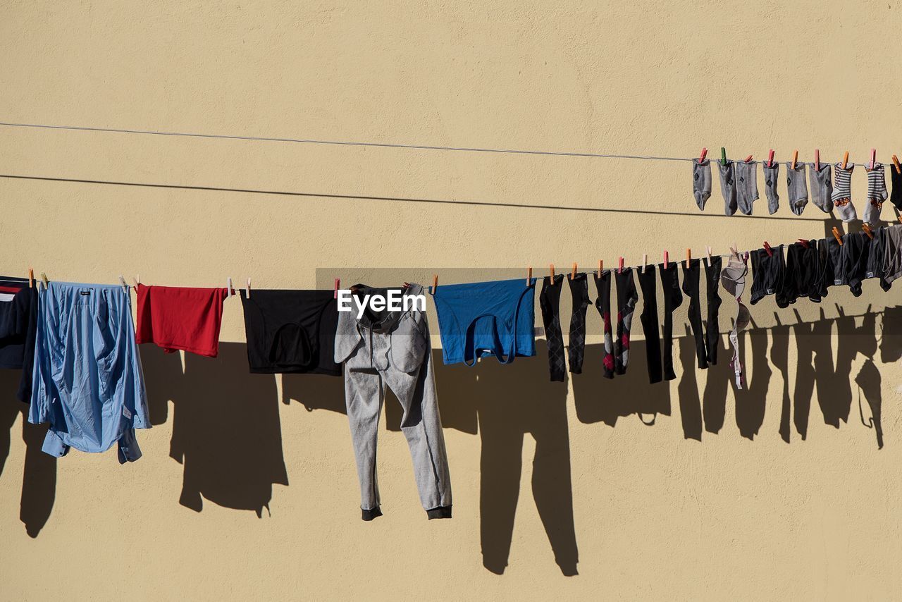 Clothes drying on clothesline against wall