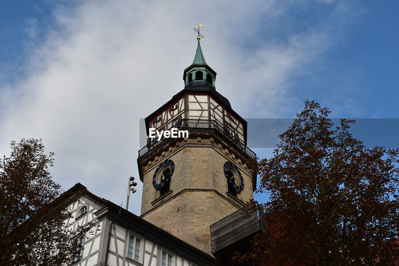 LOW ANGLE VIEW OF CLOCK TOWER AGAINST CLOUDS