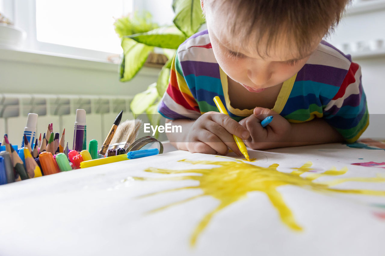 close-up of girl drawing on paper at home