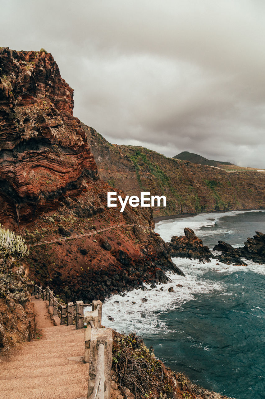 Scenic view of sea and mountains against sky