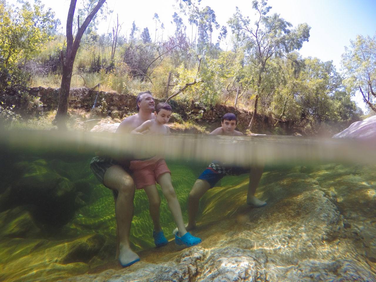 Father playing with sons in river