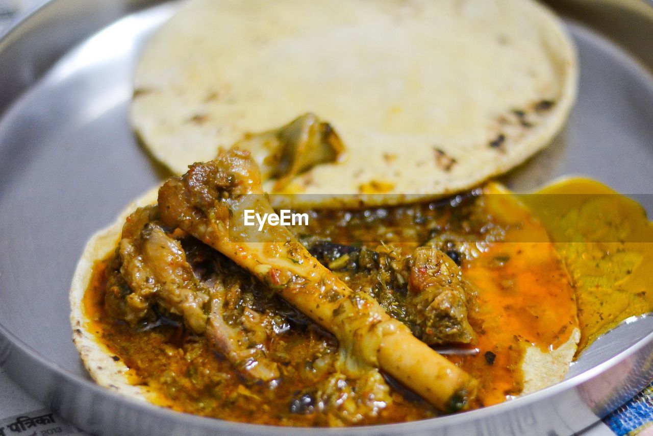 Close-up of meat and chapati on plate