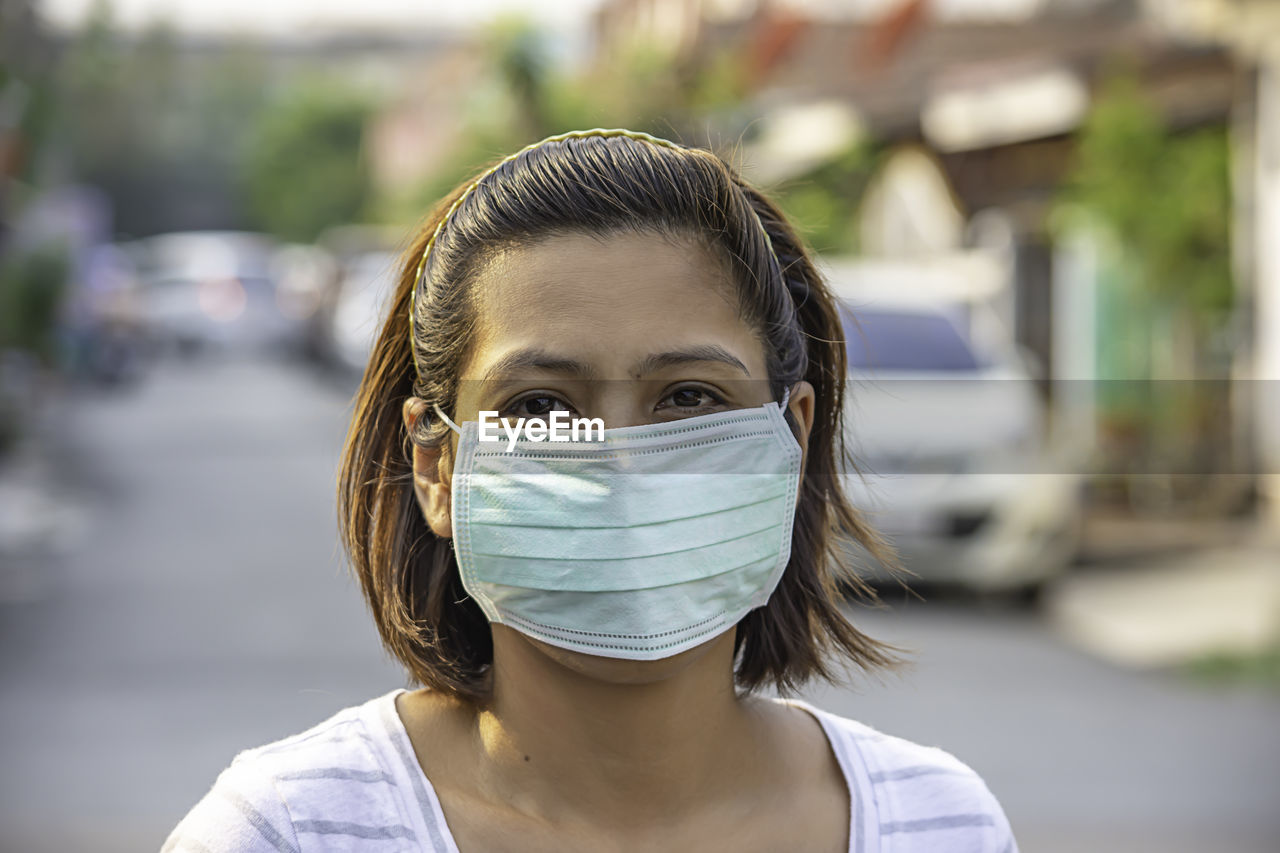 Portrait of woman in protective mask standing outdoors