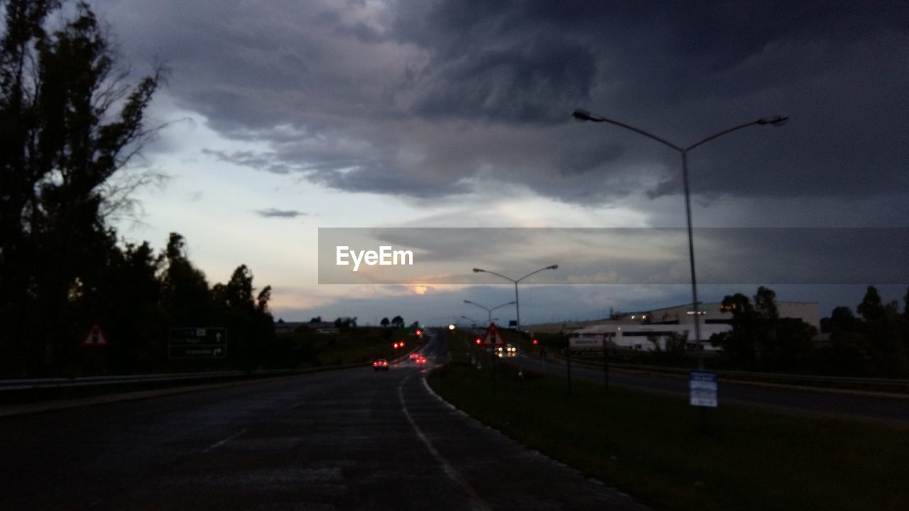 VIEW OF ROAD AGAINST CLOUDY SKY