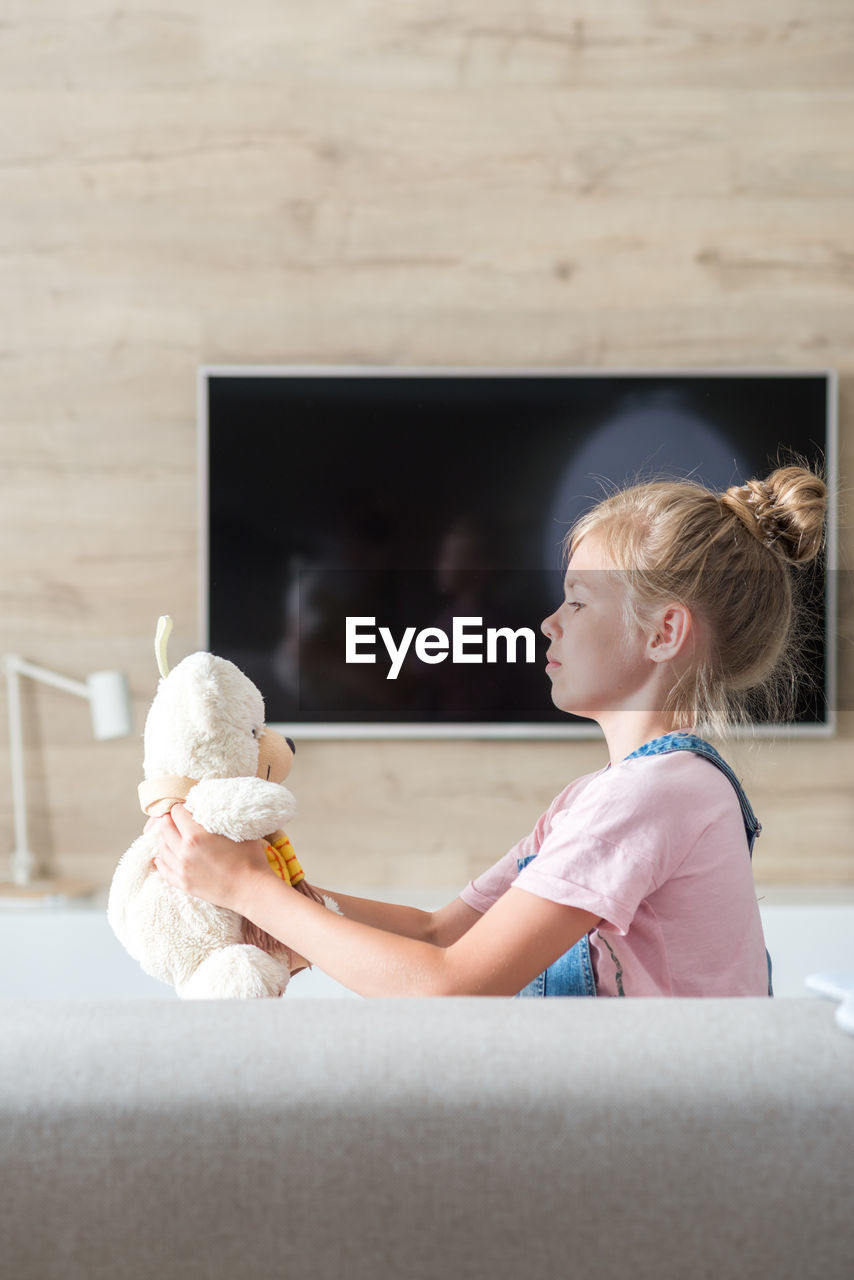 Side view of girl playing with toy