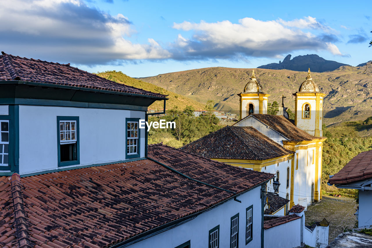 Historic church tower in baroque architecture, old colonial houses with the mountains in ouro preto