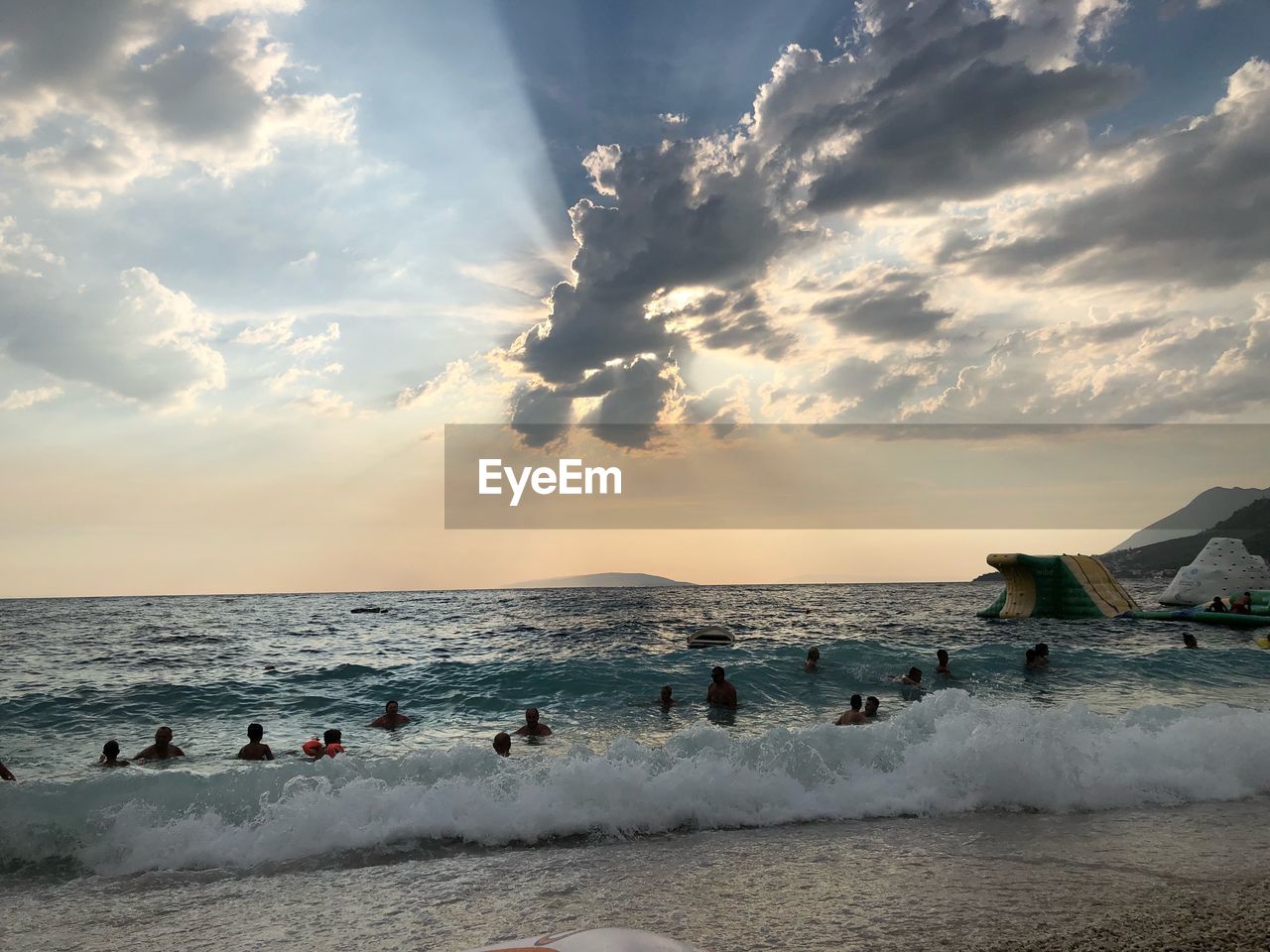 GROUP OF PEOPLE ON BEACH AGAINST SKY