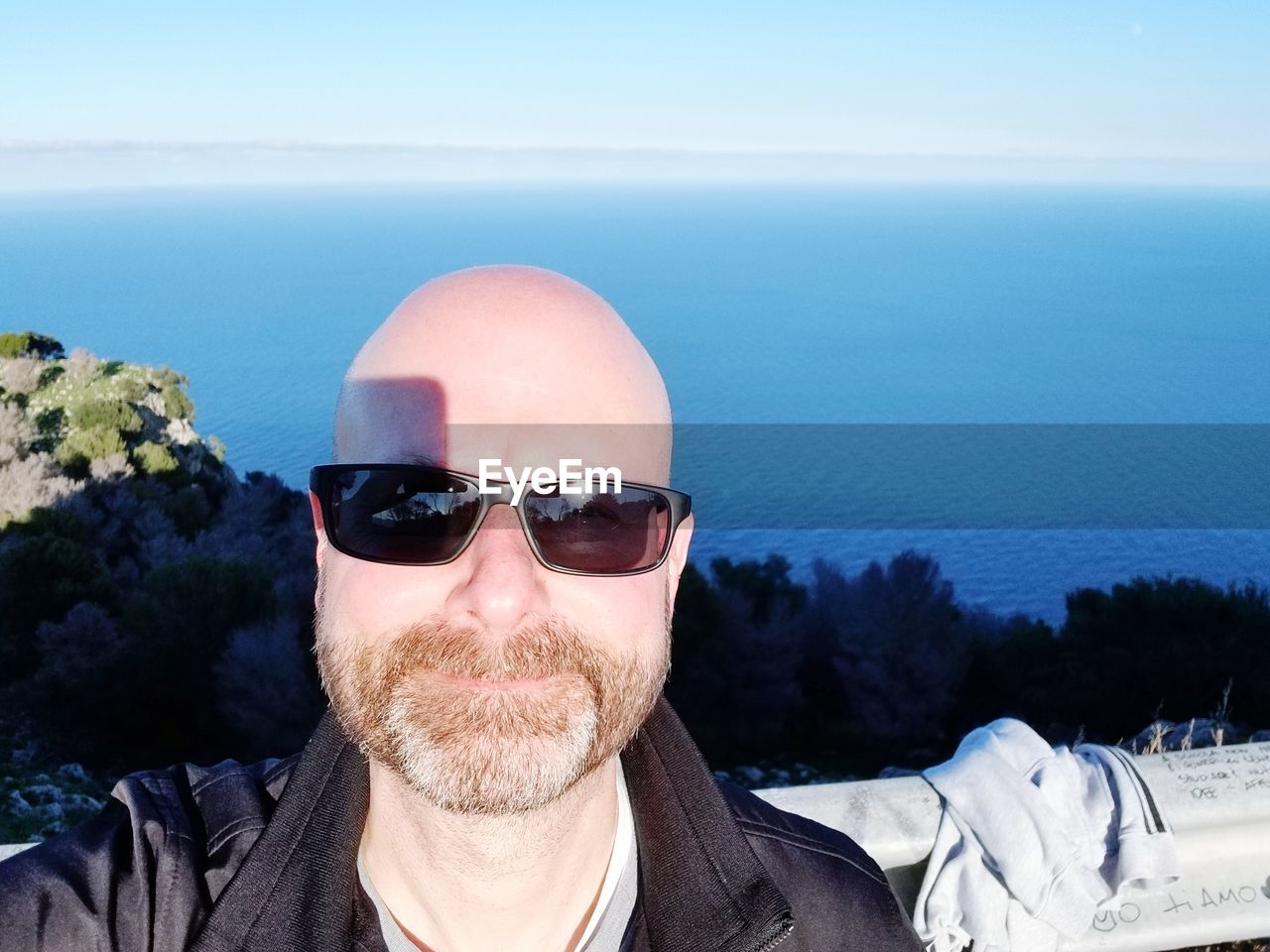 Portrait of man wearing sunglasses against sea
