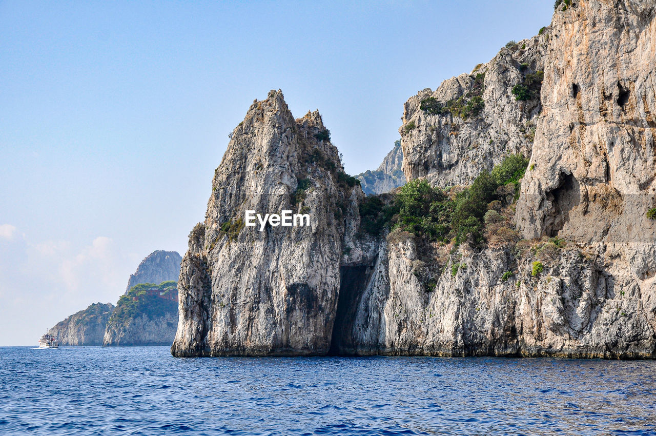 ROCK FORMATIONS IN SEA AGAINST SKY