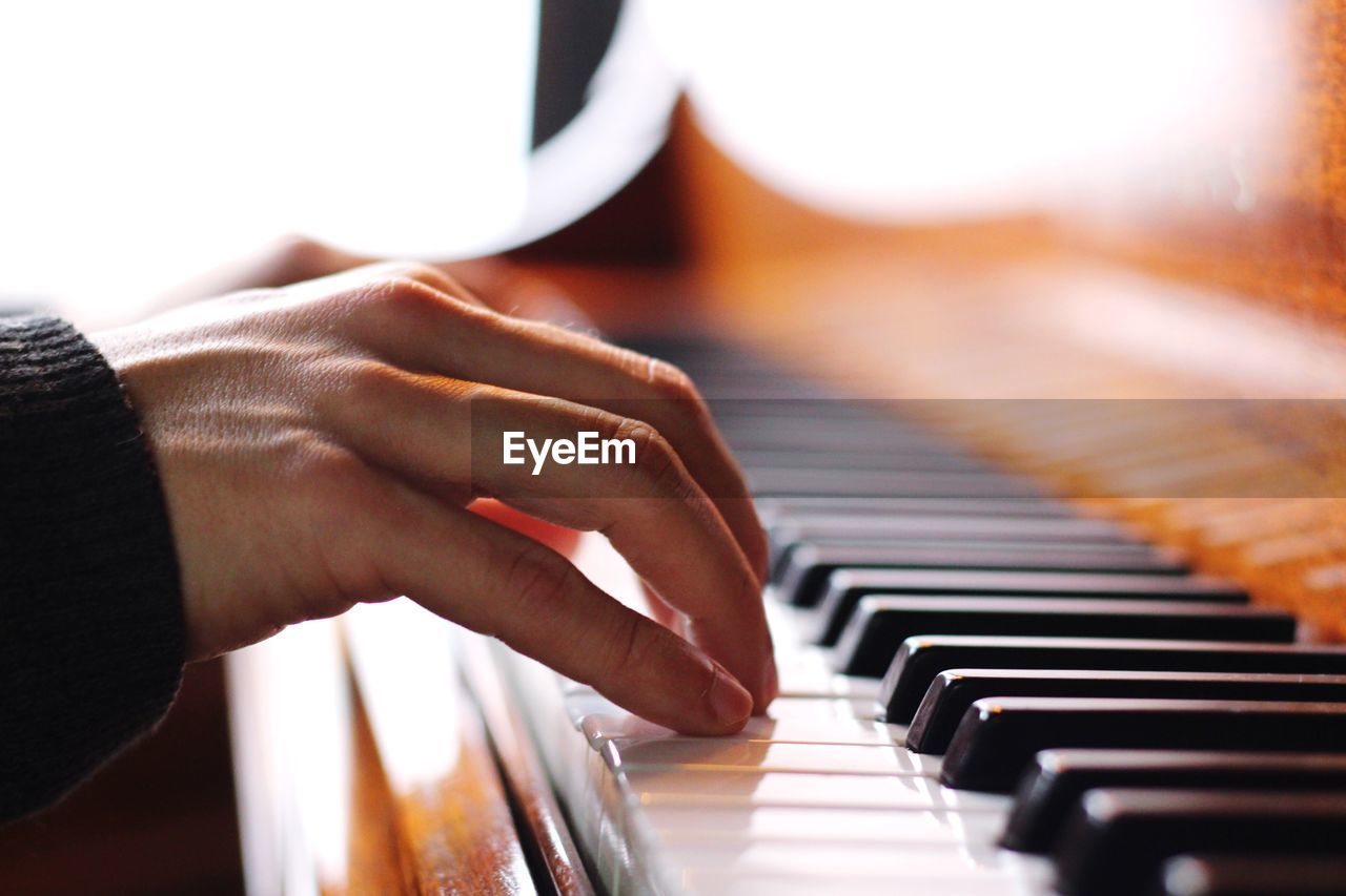 Close-up of hand playing piano
