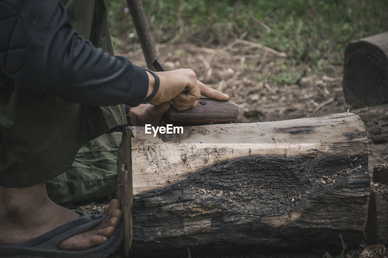 Low section of man carving wood