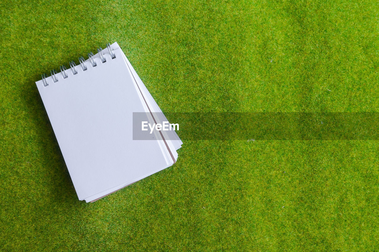 Directly above shot of spiral notebook on grass