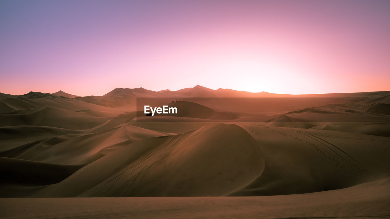 Scenic view of desert against sky during sunset