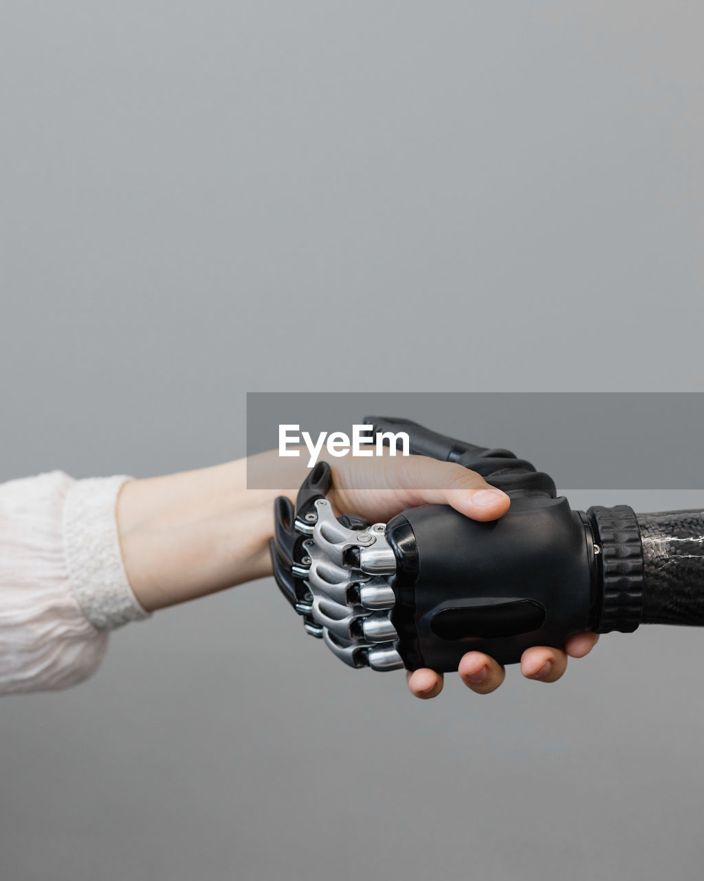 The human hand and the cyber hand bionic prosthesis make a handshake and greeting