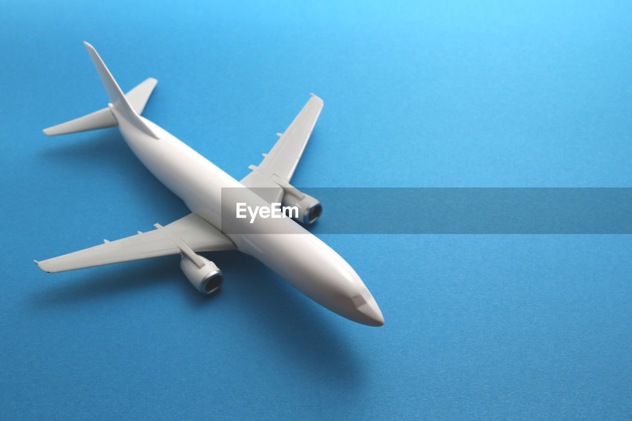 Close-up of model airplane over blue background