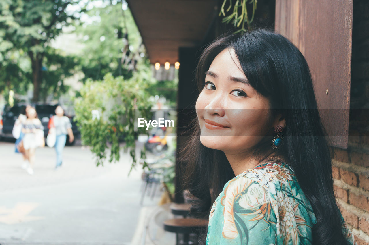 Portrait of beautiful young woman standing outdoors