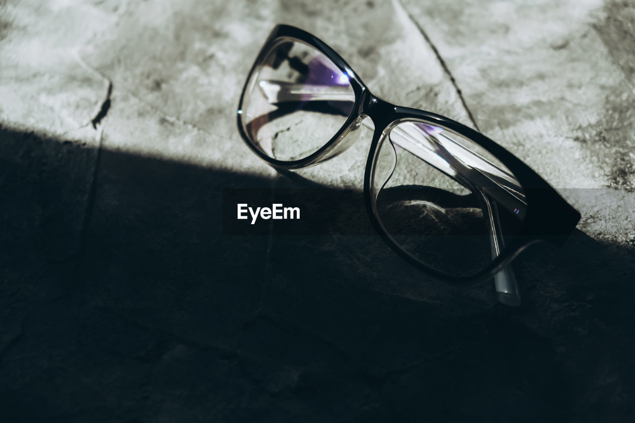 CLOSE-UP OF SUNGLASSES ON TABLE