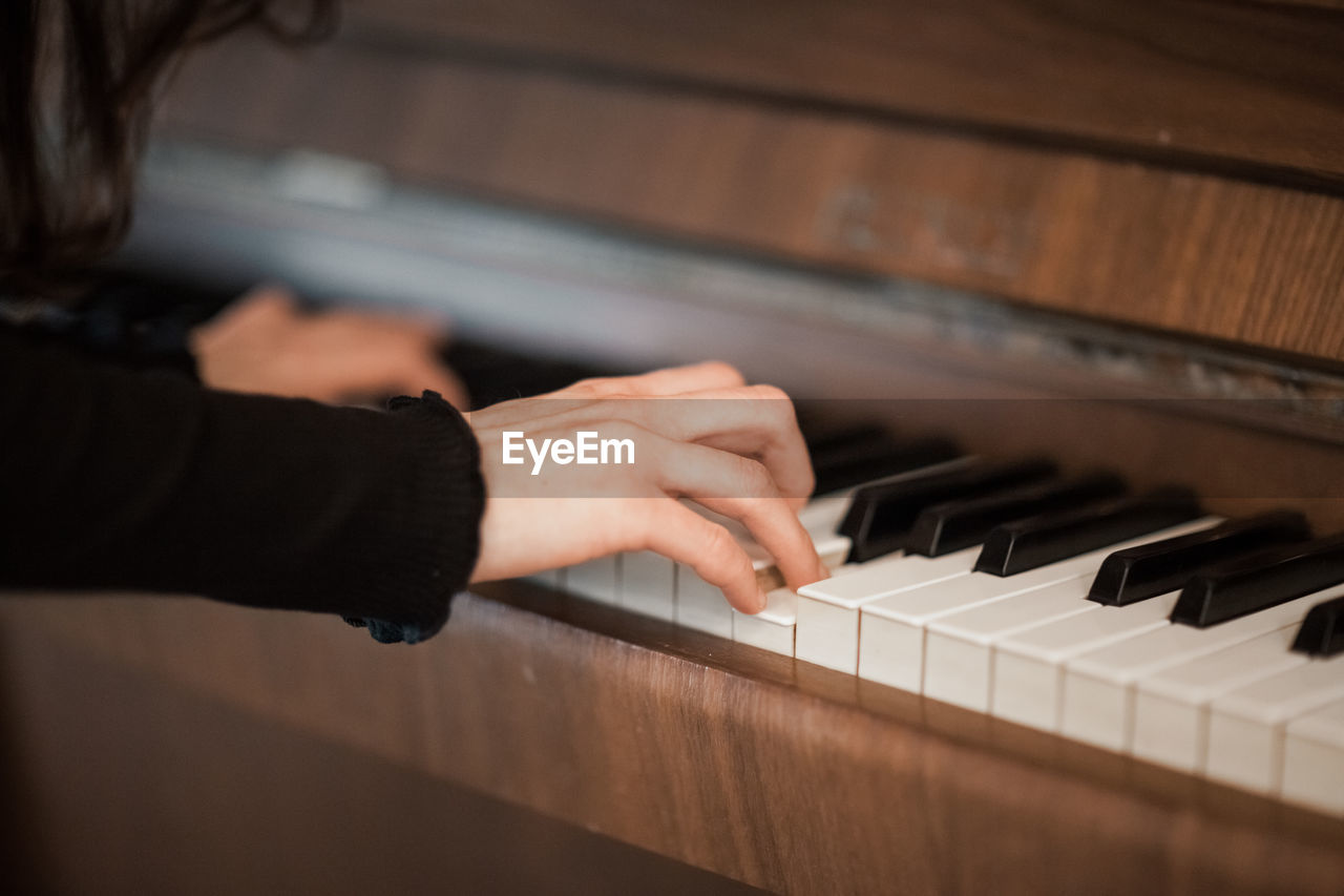 Cropped hands playing piano