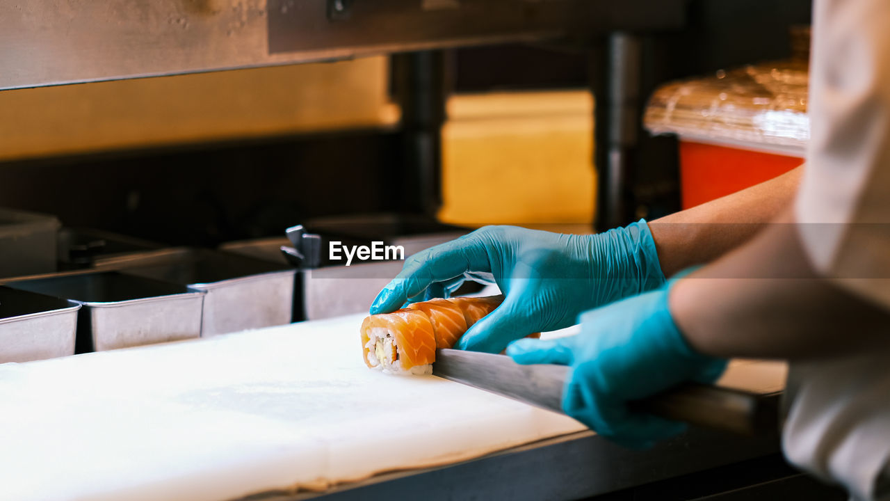 Chef cutting salmon on kitchen counter in restaurant