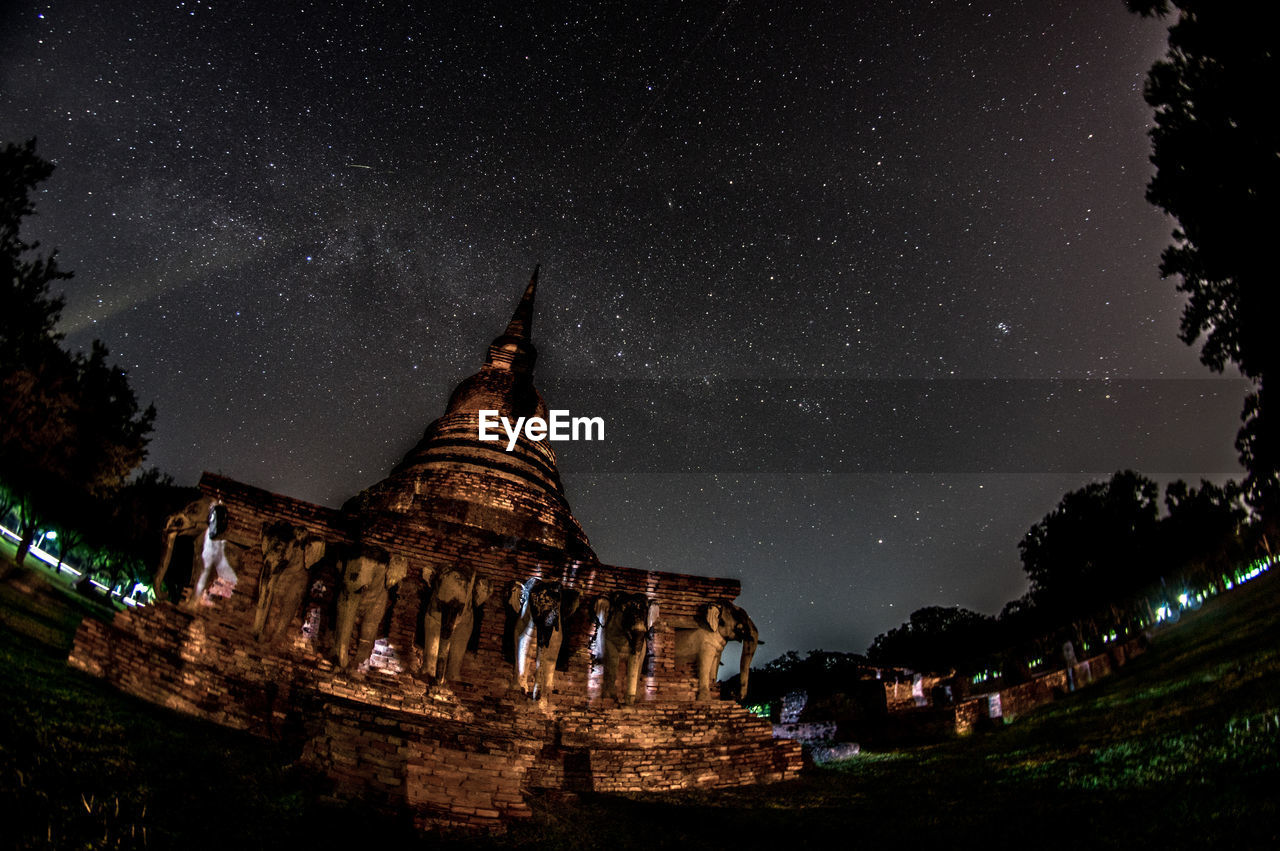 VIEW OF TEMPLE AGAINST BUILDING AT NIGHT