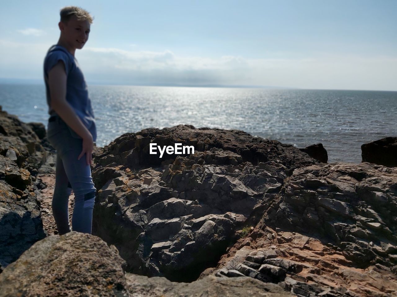 MAN LOOKING AT SEA AGAINST SKY