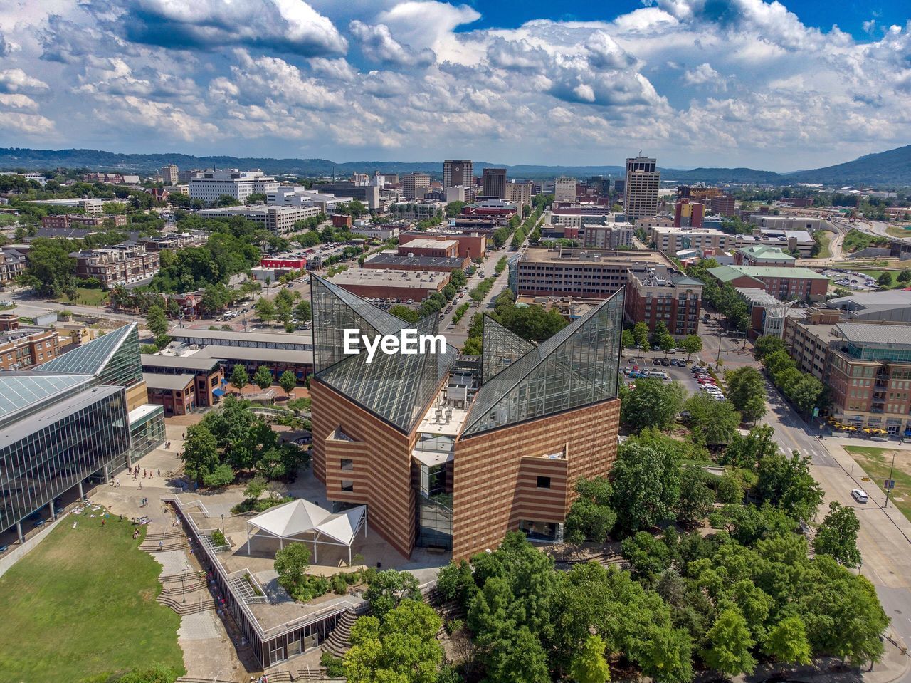 HIGH ANGLE VIEW OF CITY BUILDINGS AGAINST CLOUDY SKY