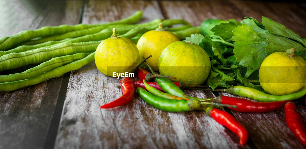 HIGH ANGLE VIEW OF TOMATOES AND VEGETABLES ON TABLE