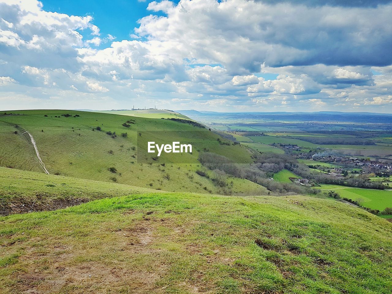 Scenic view of grassy field against cloudy sky